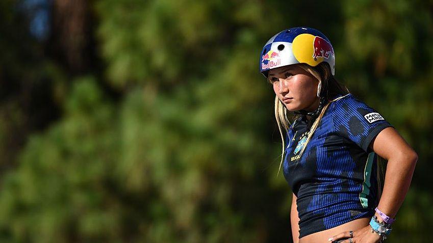 Sky Brown in dark blue and black top and skateboarding helmet