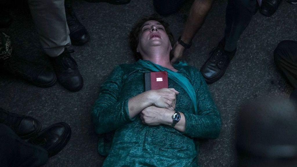 Congress lawmaker Priyanka Gandhi Vadra hugs a copy of India's constitution as she lies down on the road during a protest this week