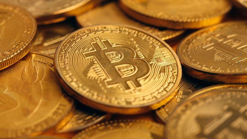 The photo illustration shows gold coins of the Bitcoin cryptocurrency.