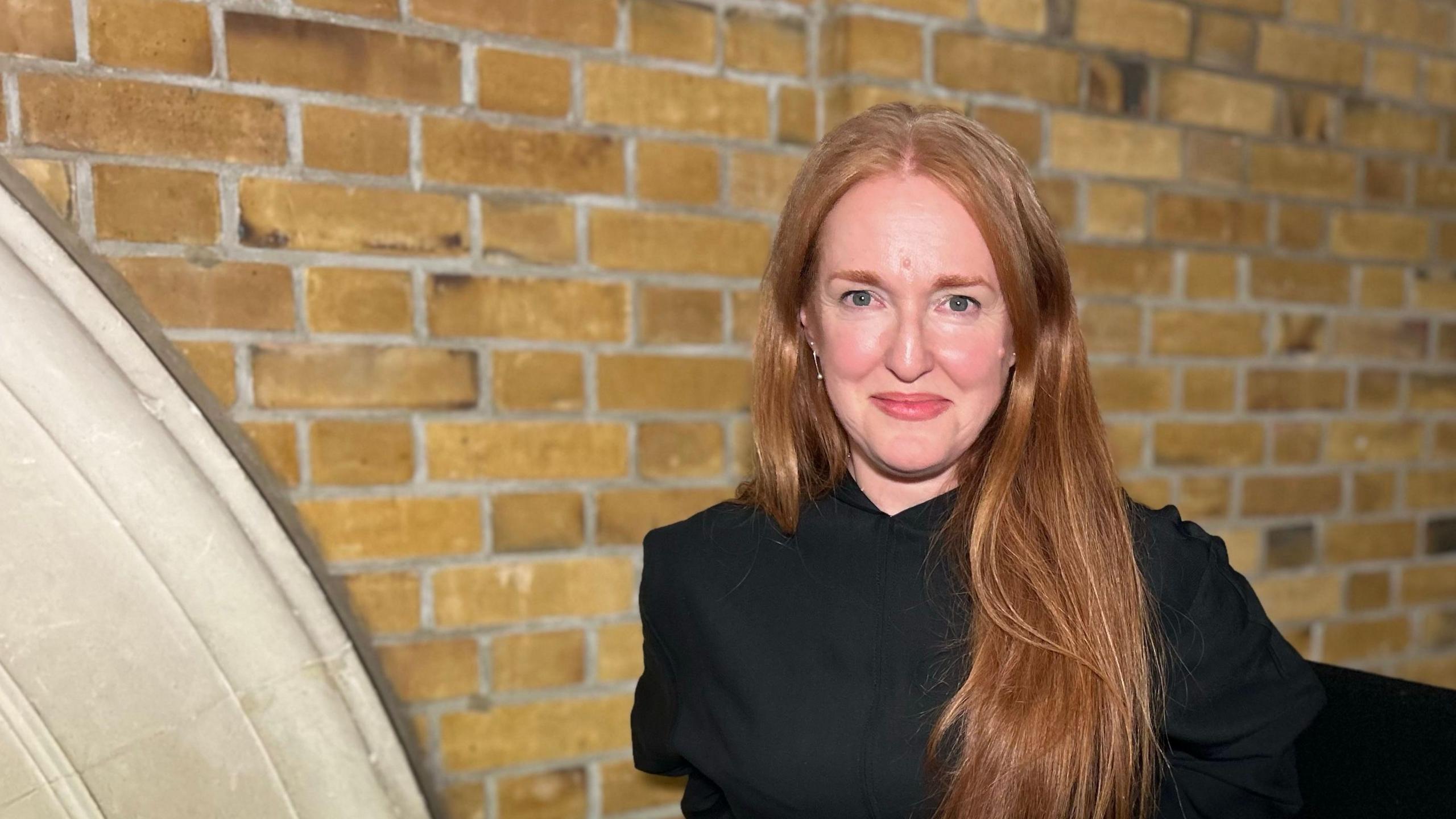 Mary Duggan with long hair wearing black at the award ceremony