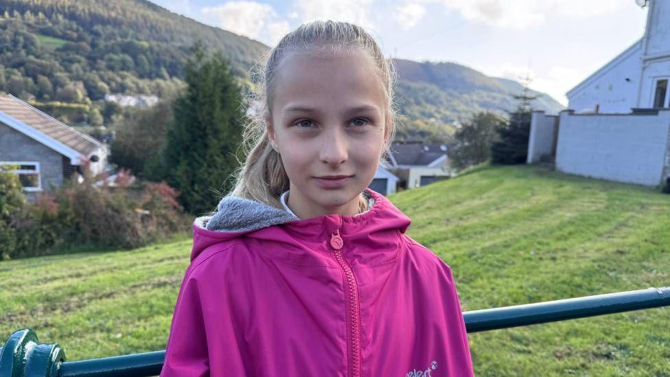 A young girl in a pink jacket