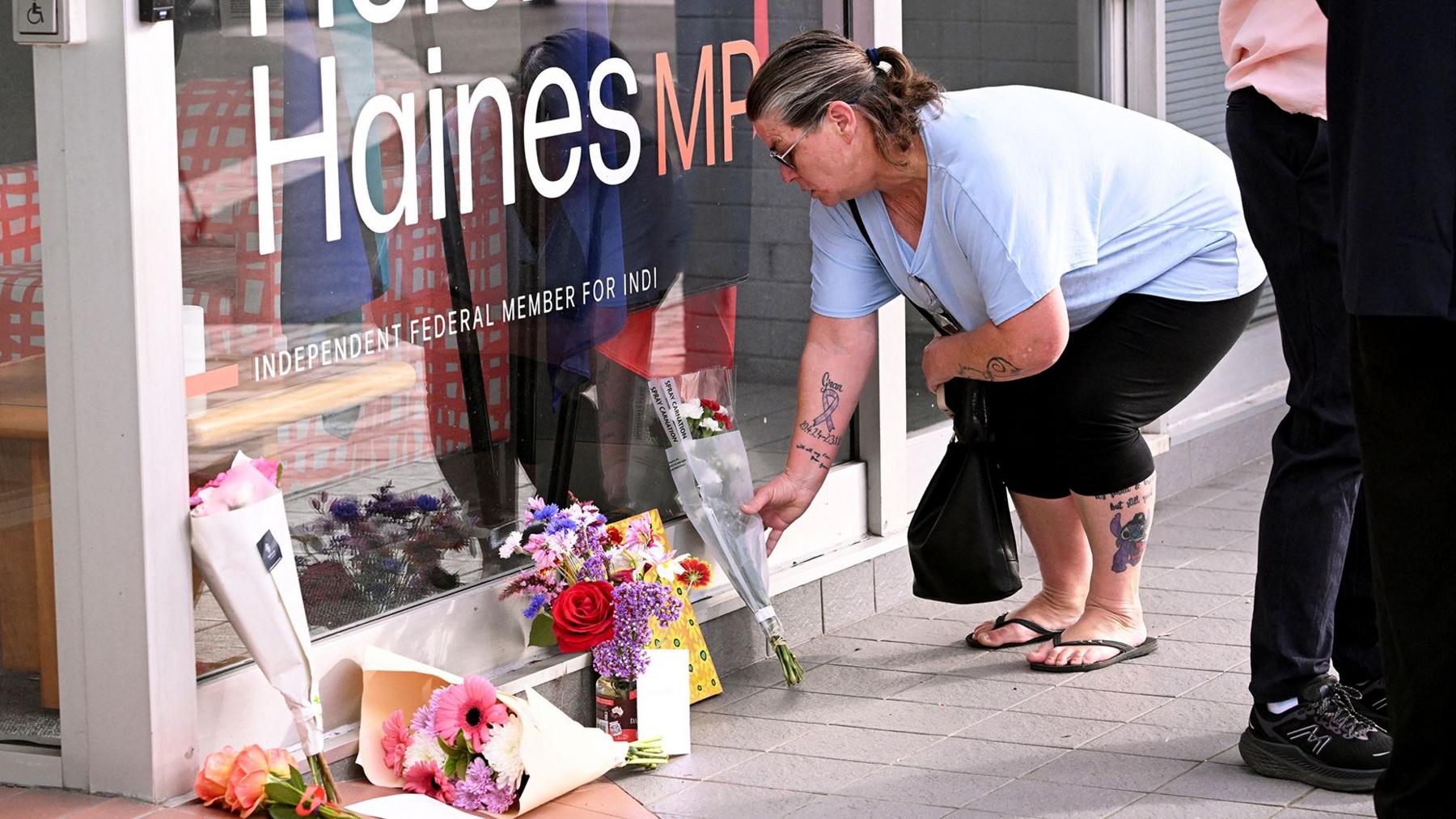 A woman lays a floral tributes at Helen Haines' office in Wangaretta