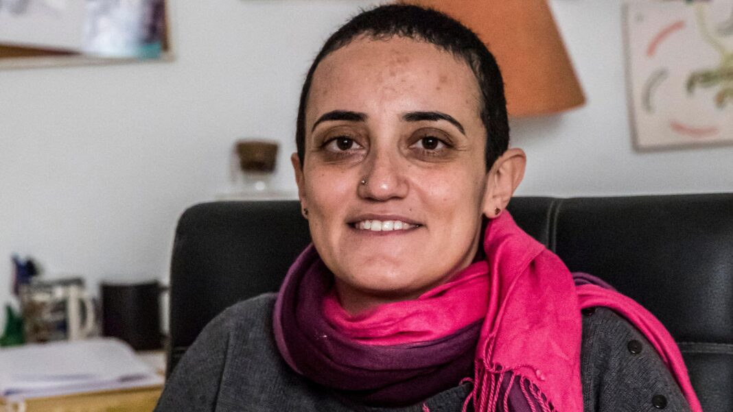 Egyptian journalist Lina Attalah detained after court orders news site’s closure Egyptian journalist Lina Attalah sits on a black leather chair. She has a red scarf around her neck, a grey top, cropped black hair, stud earrings and and a silver metal studd in her right nostril, a broad smile on her lips.