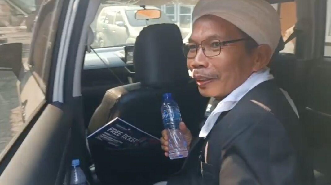 Headmaster detained after BBC investigation into alleged sexual abuse of students A man, holding a water bottle, is getting out of the back seat of a car.