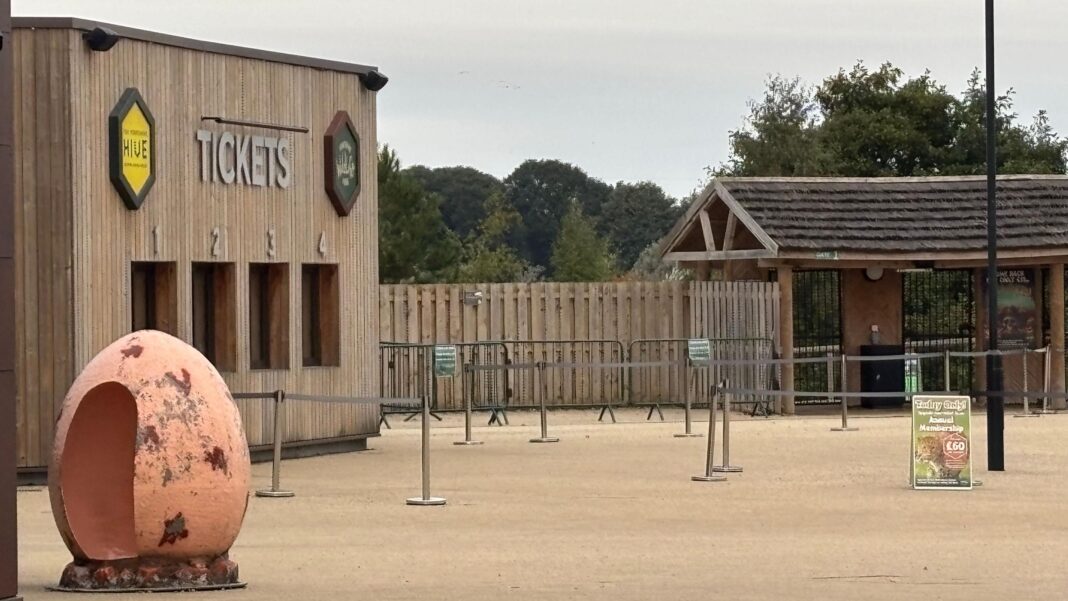 Ticket desks at the entrance to Yorkshire Widlife Park - a wooden building with barriers in front