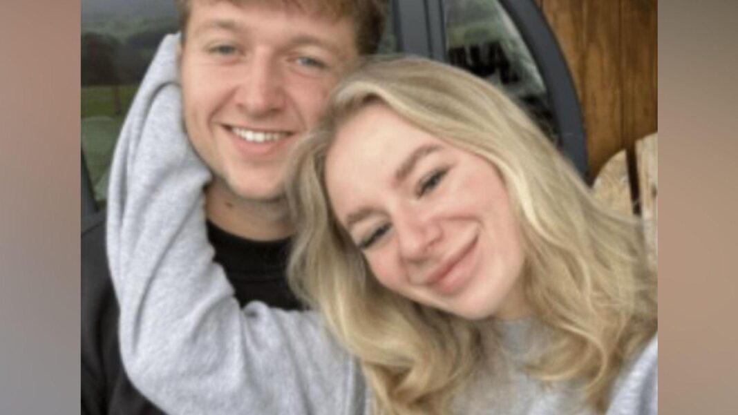 Sam Littler, in his 20s, who has dark blonde hair and a black t-shirt, smiles at the camera. Lucy Harrison, 23, who has wavy blonde hair and a grey sweatshirt, rests her head agains his cheek and holds her right hand to his face affectionately.