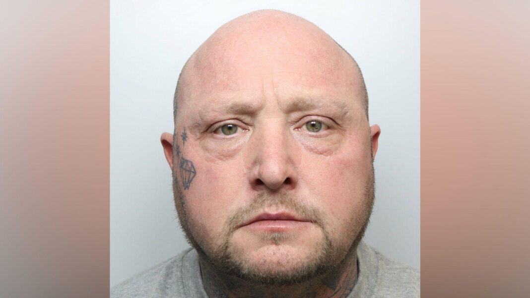 A police mugshot of David Barraclough. He has a bald head and tattoo of a crystal and a number of stars on his right cheek.