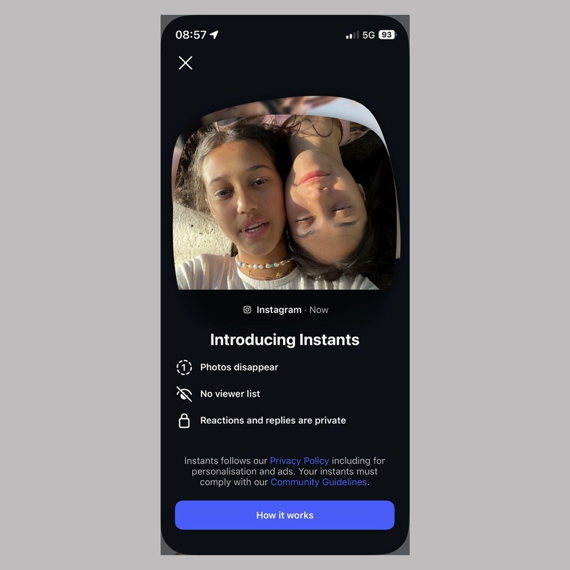 A screenshot of Instagram Instants. It shows a selfie taken by two young women, above a caption saying "Introducing Instants". Descriptions beneath it inform the user that "photos disappear", there is "no viewer list" and that "reactions and replies are private". Users are pointed to a big blue button to proceed with using it or find out "how it works".