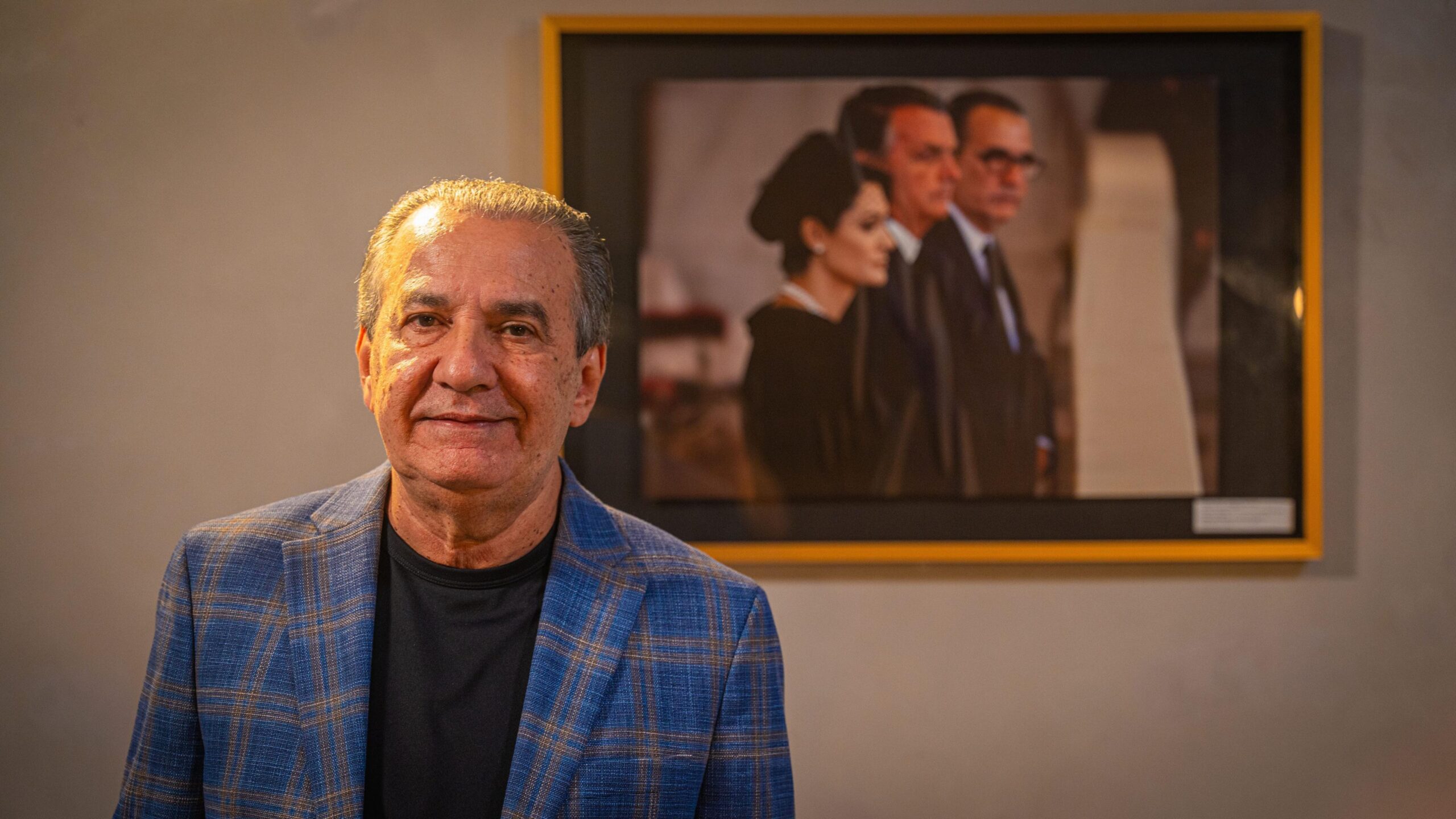 Silas Malafaia standing in front of a picture of Bolsonaro Senior