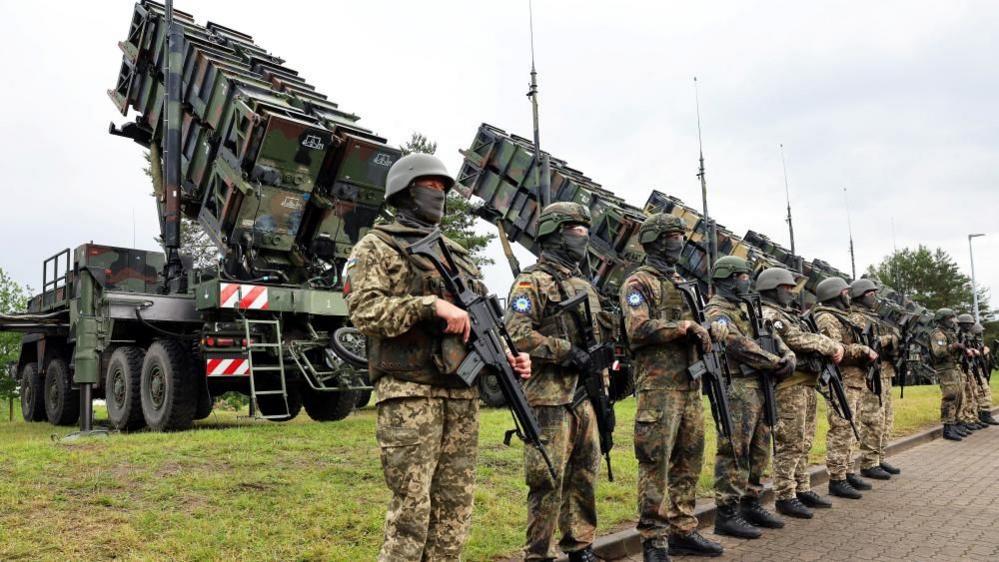 Soldiers stand during Ukrainian President Volodymyr Zelenskiy's visit to a military training area to find out about the training of Ukrainian soldiers on the “Patriot” anti-aircraft missile system, at an undisclosed location, in Germany, June 11, 2024.