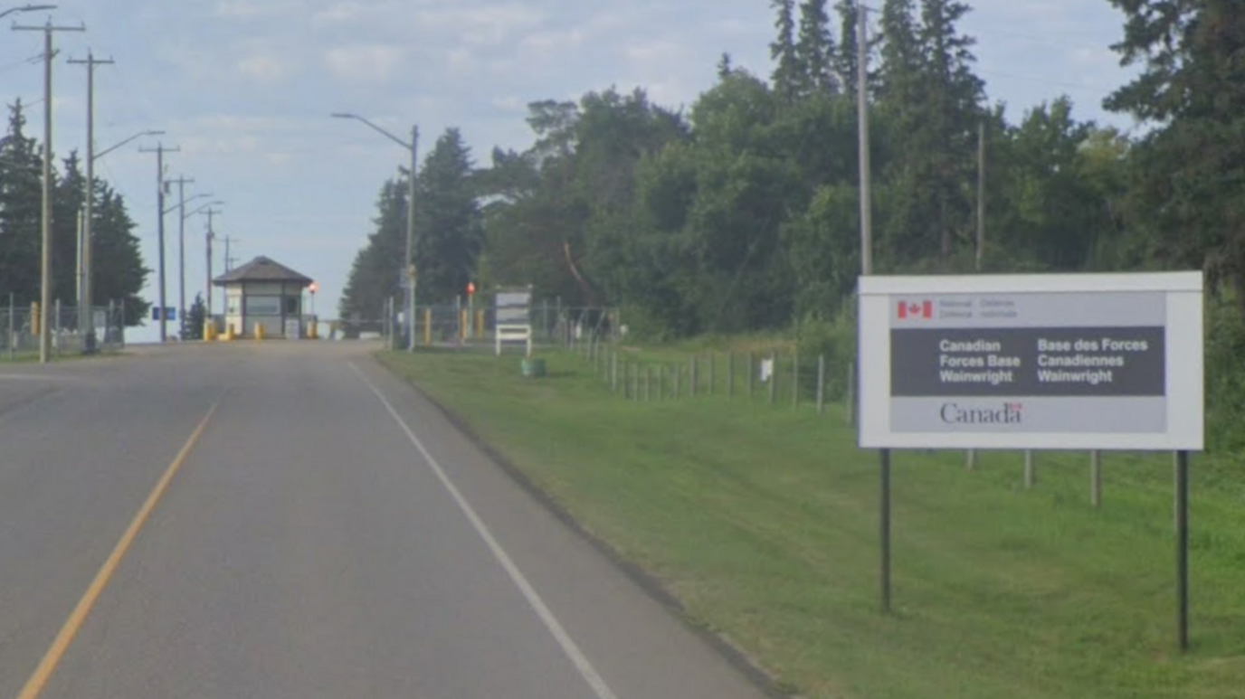 Canadian Forces Base Wainwright entrance at the end of a road, with a sign on the right hand side of the road
