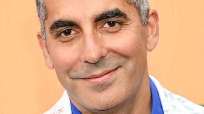 Sunil Malhotra smiling while wearing a white jacket