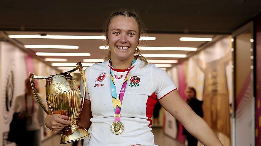 Zoe Stratford of England celebrates with the Women's Rugby World Cup Trophy