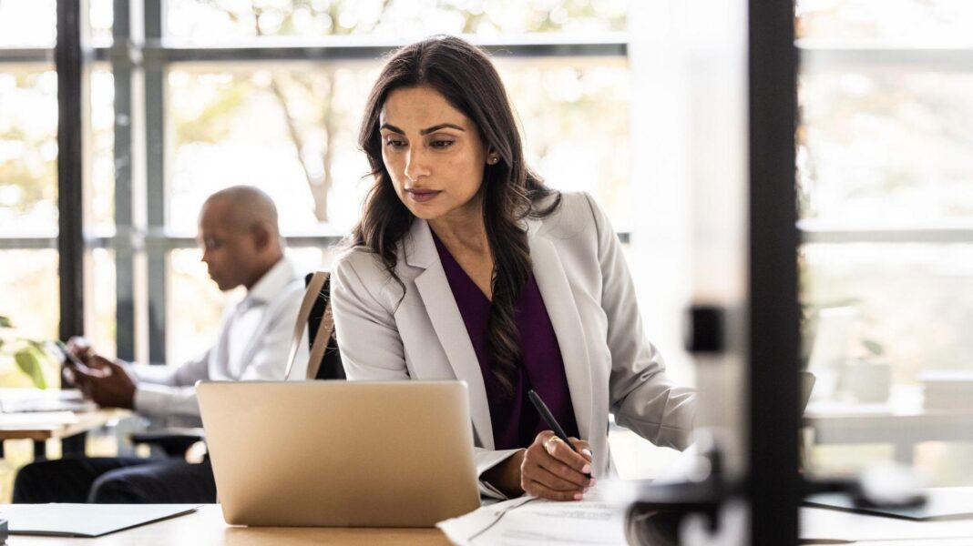 You may get the right to find out what your colleagues earn – here’s why A woman looks at a laptop computer with a colleague in the background - stock shot