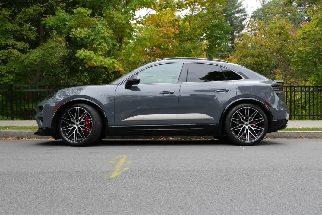 A Porsche Macan sits in front of trees that are changing color.