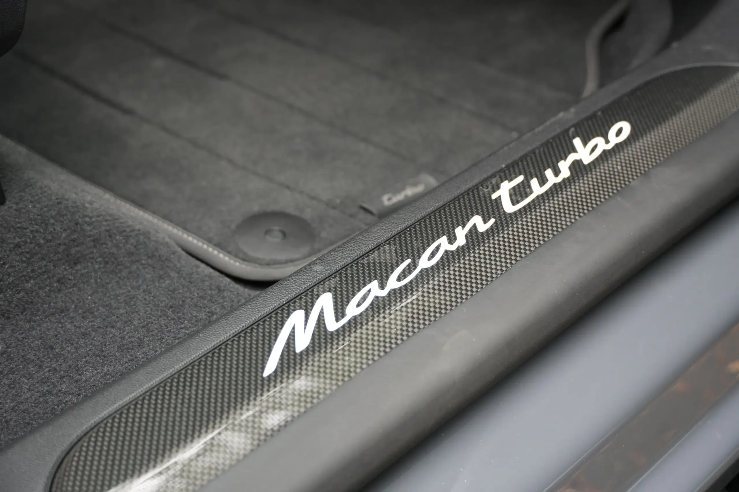 Carbon fiber door sills reflect light from above.